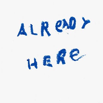 "Already Here" handwritten by a child in blue, using oil pastel